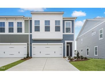 Charming townhome with a one car garage, blue siding, and well-manicured front yard at 20 Nettle Ln # 239, Clayton, NC 27520