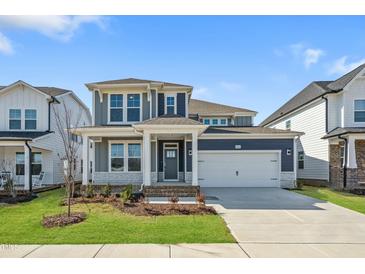 Charming two-story home featuring blue siding, a two-car garage, and manicured landscaping at 441 Edison Rail Ln, Knightdale, NC 27545