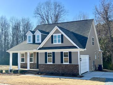 Charming home featuring a gray exterior, brick accents, and a welcoming front porch at 294 White Azalea Way, Homesite 74, Benson, NC 27504