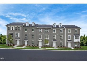 Three-story townhouses with gray siding, white trim, and a spacious front yard at 2103 Pitchfork Ln, Durham, NC 27713