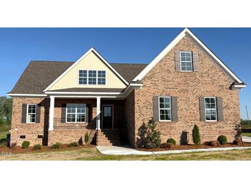 Beautiful brick home with shuttered windows, covered porch and charming architectural details under a bright blue sky at 7553 Sweetwater Dr, Nashville, NC 27856