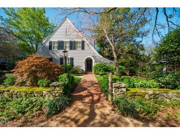 Charming home featuring a unique architectural design with lush landscaping and a welcoming brick walkway at 205 N Boundary St, Chapel Hill, NC 27514