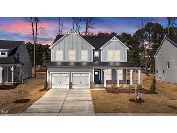 Beautiful two-story home with gray siding, a front porch, and a two-car garage at 317 Highland Ridge Ln, Knightdale, NC 27545