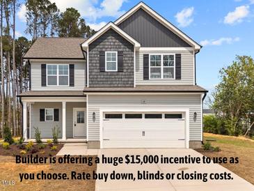 Charming two-story home featuring a modern exterior, a two-car garage, and well-maintained landscaping at 60 Bennett Rd, Coats, NC 27521