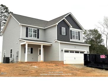 Charming two-story home with gray siding, black shutters, and a two-car garage at 60 Bennett Rd, Coats, NC 27521