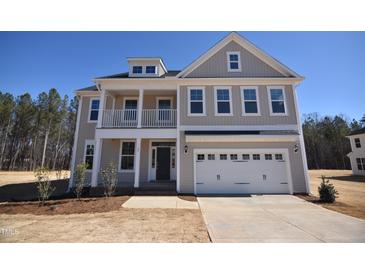 Charming two-story home featuring a welcoming front porch, a two-car garage, and classic architectural details at 35 Accord Dr, Youngsville, NC 27596
