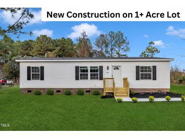 Charming new construction home featuring a landscaped yard and a welcoming entrance on a spacious 1+ acre lot at 1235 Schloss Rd, Louisburg, NC 27549