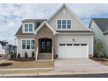 Charming home featuring a brick entryway, a two-car garage, and a well-manicured front yard at 201 Wash Hollow Dr, Wendell, NC 27591