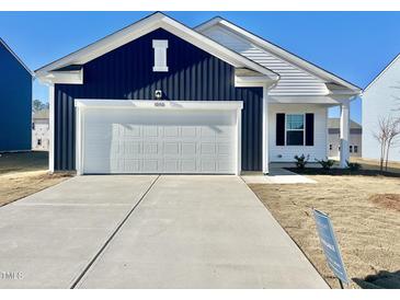 Two-toned house with white and blue siding, a white garage door, and a landscaped yard at 1050 Parkside Drive, Nashville, NC 27856