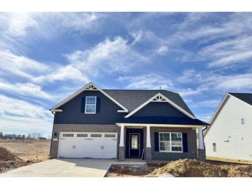 Charming new construction home featuring a grey brick and siding exterior with a two-car garage at 1064 Fairhaven Dr # 95, Mebane, NC 27302