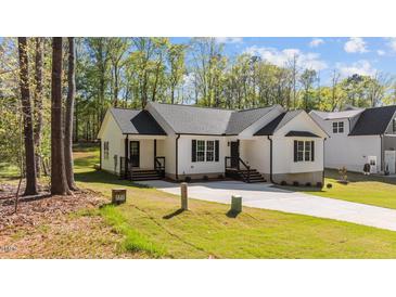 Charming white home with a well-manicured lawn and inviting front porch at 132 Prairie Dog Dr, Louisburg, NC 27549