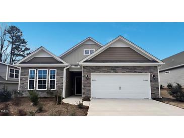 Charming home with stone accents, neutral siding, a two-car garage, and professionally landscaped yard at 1688 Abberly Pl, Graham, NC 27253