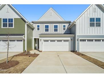Charming townhome with a two-car garage and inviting curb appeal on a bright, sunny day at 909 Montague Ave, Durham, NC 27703