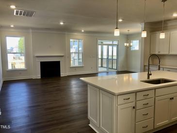 Bright living area features dark floors, fireplace, and screened-in porch access for seamless indoor-outdoor living at 1600 Maelyn Way, Fuquay Varina, NC 27526