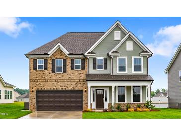 Charming two-story home featuring a brick and siding exterior, complemented by a well-manicured lawn and a two-car garage at 2750 Lacy Holt Rd, Graham, NC 27253