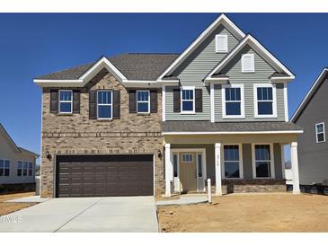 Two-story home with brick and vinyl siding, a two-car garage, and a covered front porch at 2750 Lacy Holt Rd, Graham, NC 27253