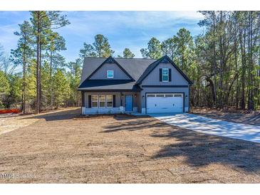 Charming two-story home with well-manicured lawn and attached two-car garage at 6967 Jefferson Davis Hwy, Cameron, NC 28326