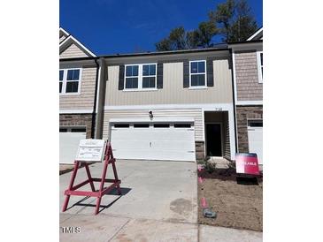 New home with beige siding, black shutters, a two-car garage and neat landscaping at 7139 Hubner Pl # 30, Cary, NC 27519