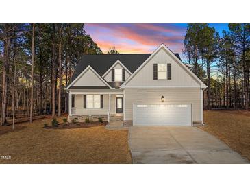 Two-story house with gray siding, white garage door, and landscaping at 75 Arbor Dr, Youngsville, NC 27596