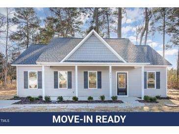 Charming single-story home with light gray siding, black shutters, and a welcoming front porch at 929 Micro W Rd, Selma, NC 27576