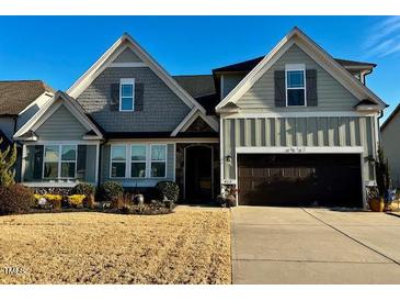 Two-story house with gray siding, dark brown garage door, and landscaping at 412 Airedale Trl, Garner, NC 27529