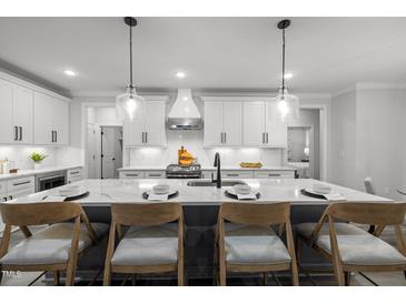 Modern kitchen island featuring a white marble countertop and seating, perfect for entertaining at 184 Dereham Ln, Garner, NC 27529