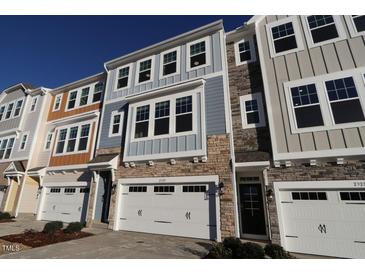 View of new townhomes featuring garages, stone accents, and varied color schemes at 2325 Bay Minette Sta # 548, Apex, NC 27502