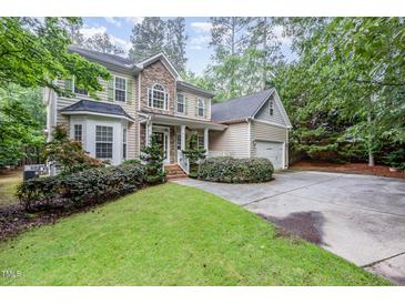 Charming two-story home boasts a stone and siding exterior, landscaped lawn, and an attached two-car garage at 1620 Dunn Rd, Raleigh, NC 27614