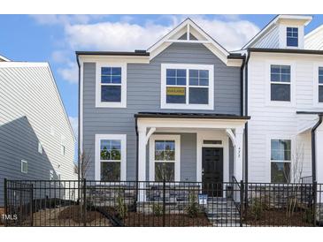 Charming two-story home with a fenced front yard and manicured landscaping at 472 Traditions Grande Blvd # 34, Wake Forest, NC 27587