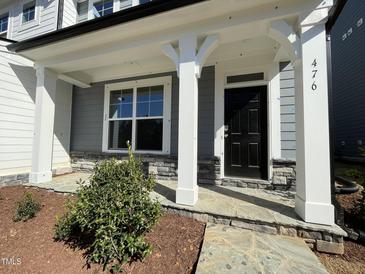 Inviting front entrance with stone accents, black front door, white trim, and stone walkway to home entrance at 476 Traditions Grande Blvd # 33, Wake Forest, NC 27587