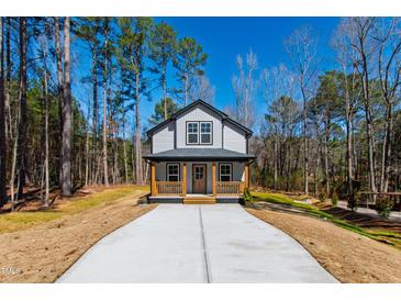 Charming two-story home with a welcoming front porch and long driveway at 169 Running Deer Dr, Louisburg, NC 27549