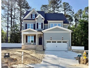 Charming two-story home with a two car garage, black shutters, and manicured lawn at 2625 Silver Gate Ct, Wake Forest, NC 27587