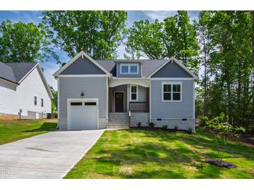 Charming craftsman home with gray siding, stone accents, and a well-manicured front yard at 235 Sequoia Dr, Louisburg, NC 27549
