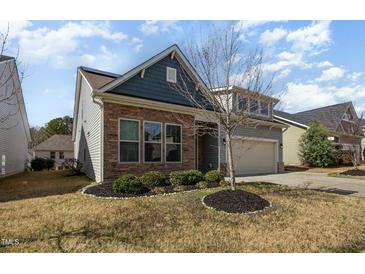Charming home featuring stone accents, a two-car garage, and well-manicured landscaping at 7533 Poplar Meadow Ln, Raleigh, NC 27616