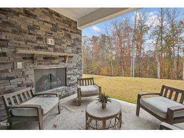 Cozy outdoor patio with stone fireplace and seating, perfect for relaxing and enjoying the view at 2021 Abbeyhill Dr # 66, Raleigh, NC 27610