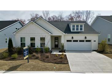 Charming single-story home with white siding, manicured landscaping, and a two-car garage at 2229 Abbeyhill Dr # 123, Raleigh, NC 27610