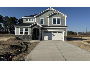Two-story home featuring gray siding, stone accents, a two car garage and a concrete driveway at 23 Barrow Ct, Angier, NC 27501