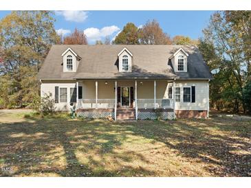 Charming home featuring a welcoming front porch, dormer windows and mature trees at 7039 Old 421 Rd, Liberty, NC 27298