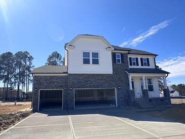Stunning two-story home featuring a stone facade and a spacious three-car garage at 199 Shelby Meadow Ln, Angier, NC 27501