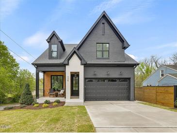 Beautiful two-story home with a gray brick exterior, a two-car garage, and a cozy front porch at 734 S State St, Raleigh, NC 27601