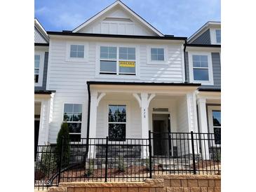 Charming two-story townhome with white siding, black trim, and a wrought iron fence at 478 Traditions Grande Blvd # 32, Wake Forest, NC 27587