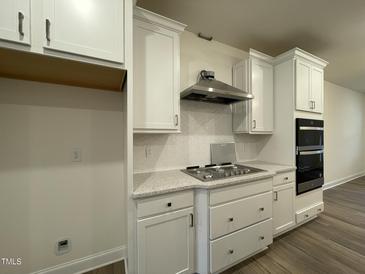 Modern kitchen featuring white cabinets, stainless steel appliances, and granite countertops at 482 Traditions Grande Blvd # 30, Wake Forest, NC 27587