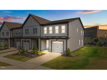 New two-story townhouse featuring a one car garage, gray siding, and manicured landscaping at 709 Jamescroft Way, Rolesville, NC 27587