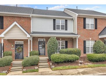 Charming brick townhome featuring manicured landscaping and inviting front entrance at 9009 Grassington Way, Raleigh, NC 27615
