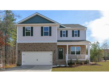 Charming two-story home with a brick facade, attached garage, and inviting front porch at 120 Tobacco Woods Dr, Youngsville, NC 27596