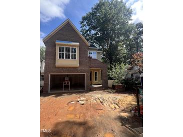 New brick home exterior with an attached garage and unfinished yard under a sunny, cloudy sky at 3302 Hall Pl, Raleigh, NC 27607