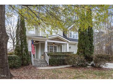 Charming two-story home featuring a covered front porch, stone steps, and a manicured front yard with mature trees at 4324 Brighton Ridge Dr, Apex, NC 27539