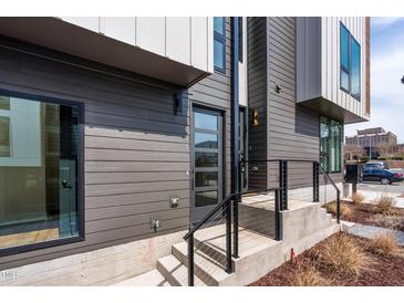 Contemporary home featuring a modern glass front door, stylish gray siding and neat, minimalist landscaping at 512 Gordon Street # 602, Durham, NC 27701