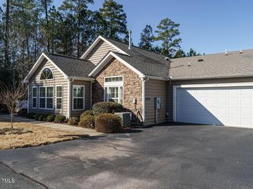 Exterior of charming ranch home with stone accents and a two-car garage at 992 Blue Bird Ln, Wake Forest, NC 27587