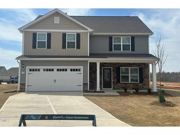 Charming two-story home features a two-car garage, stone accents, and a well-manicured lawn at 107 Wilderness Ct, Mebane, NC 27302